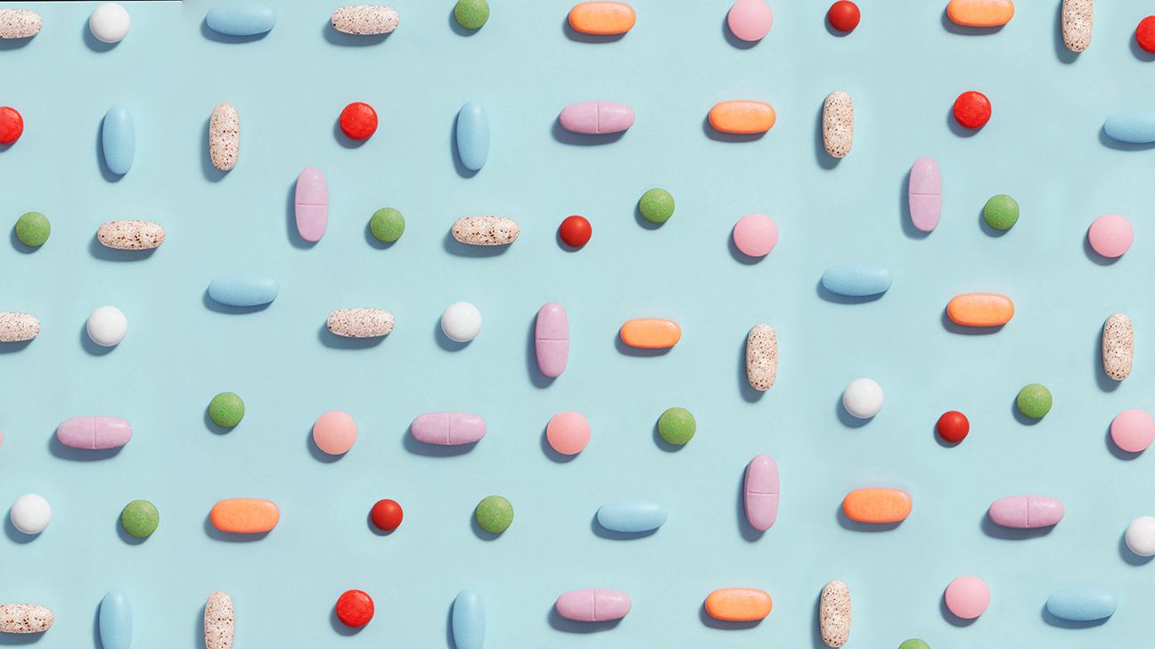 A collage of several different pills with a wide range of colors and sizes arranged in a grid pattern.