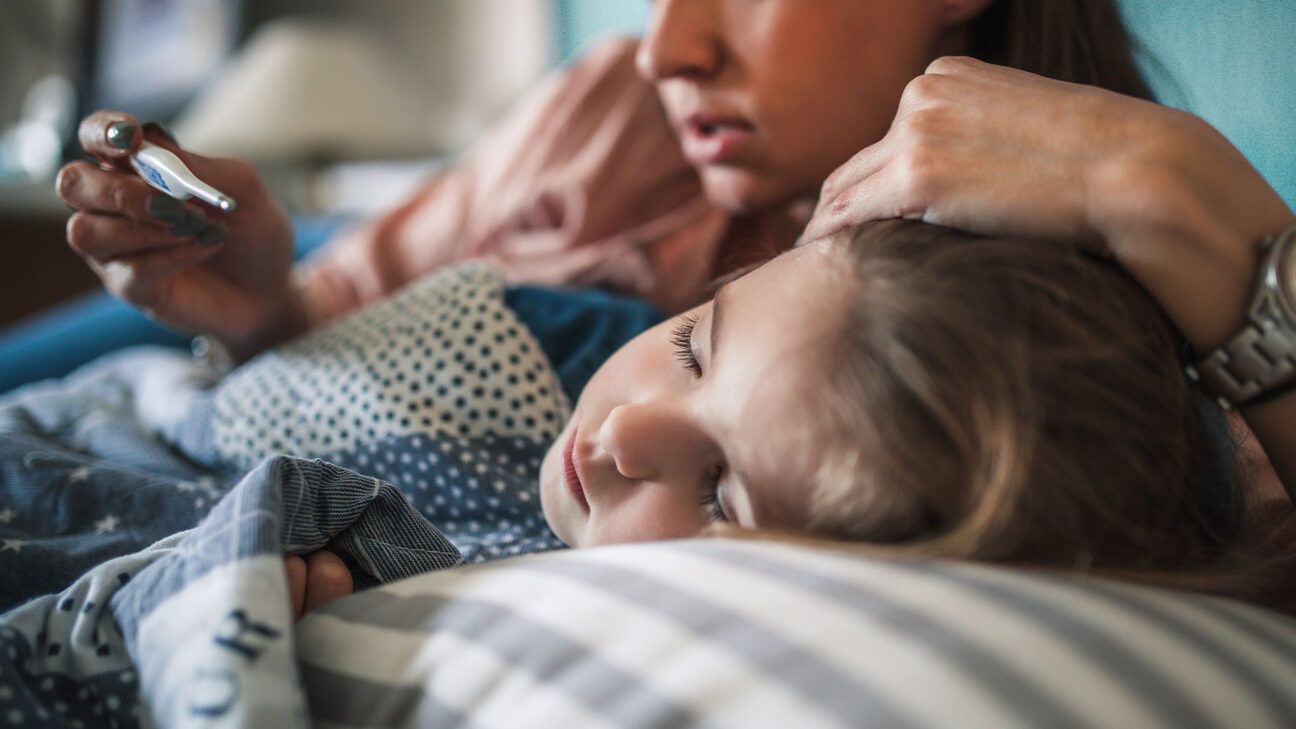 A mother comforts a sick child.