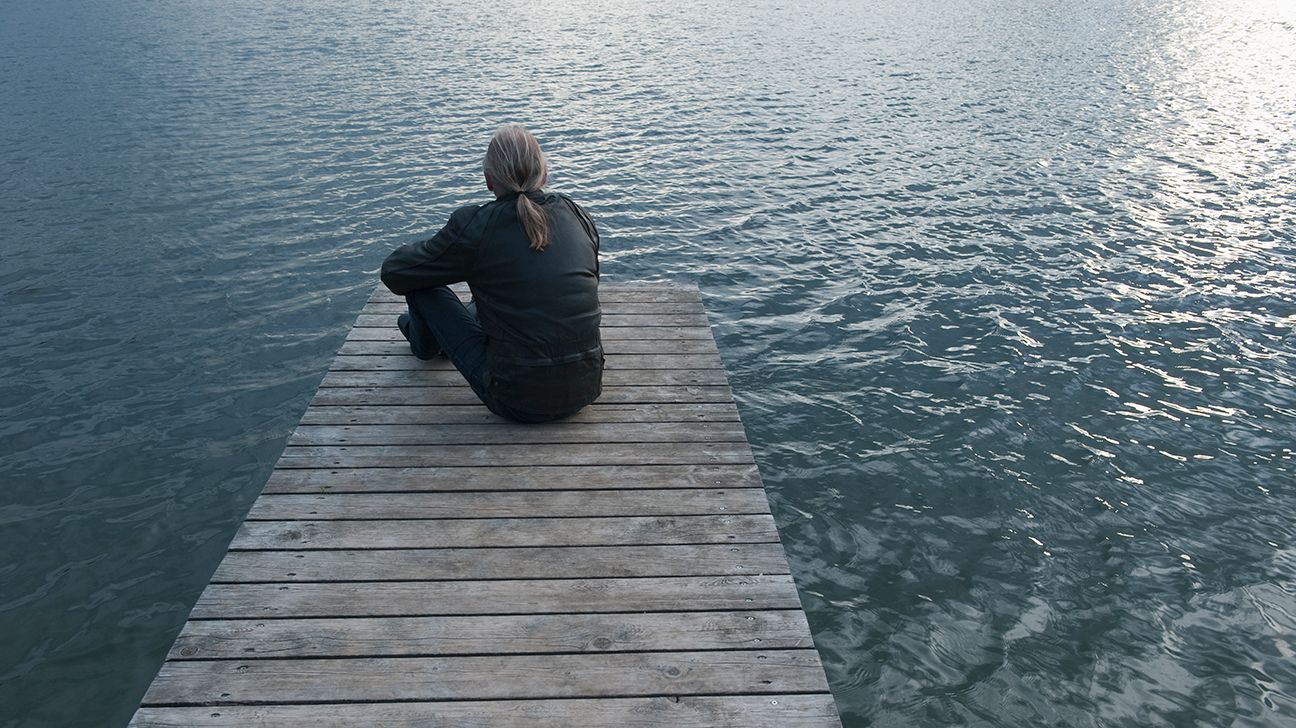 person with recurrent cancer sitting on a dock thinking-1