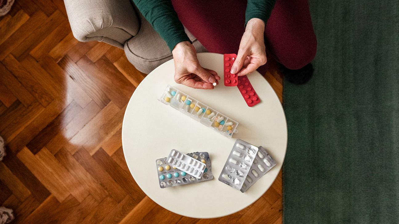 Person arranging supplements in a pill dispenser 