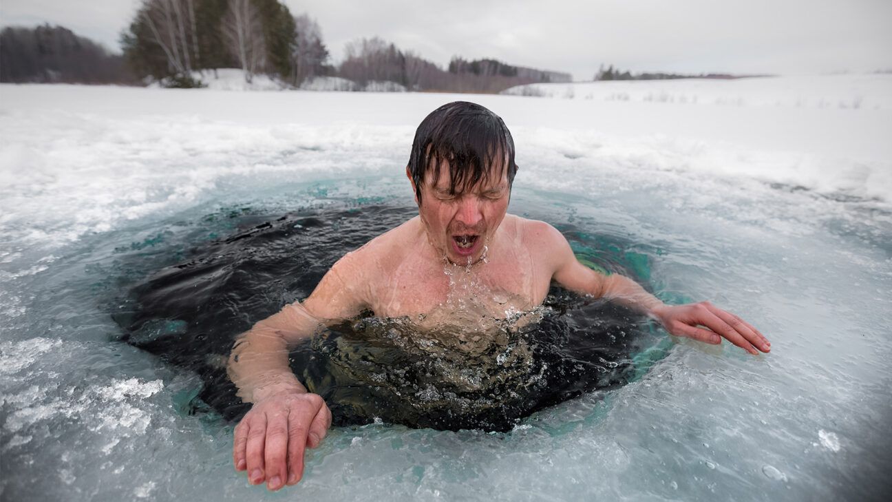 Male takes a cold plunge in an icy lake