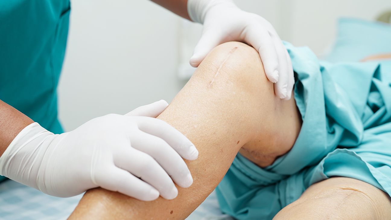 A doctor examining a person's knee.