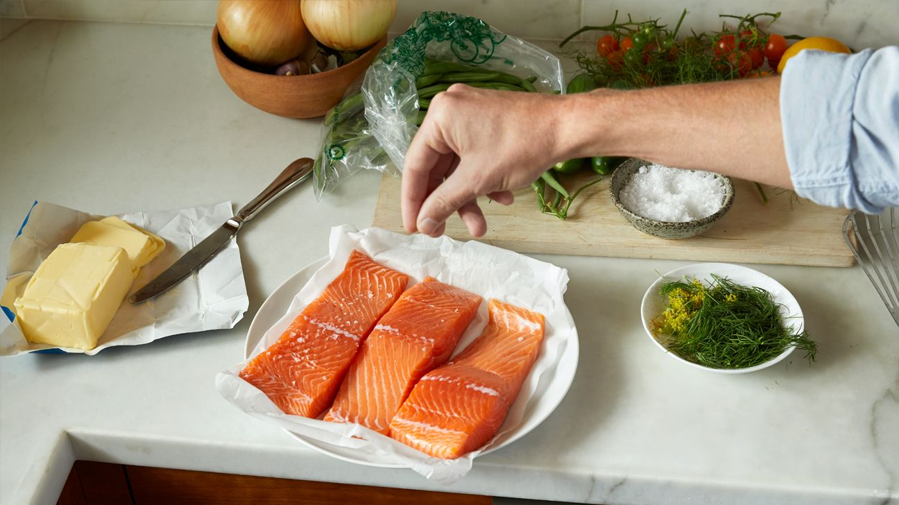 Person cooking salmon.