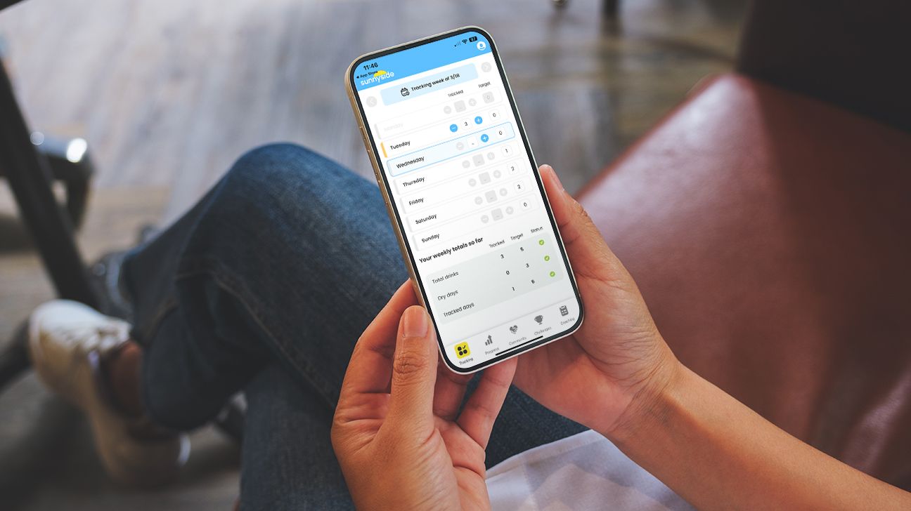 person is holding an iPhone with the screen facing them. On the screen is Sunnyside's app, open to the tracking drinks portion. The image is provided by the tester, Beanie.
