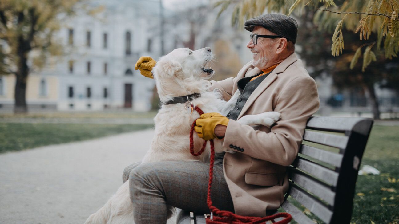 Man sitting on a bench with dog.