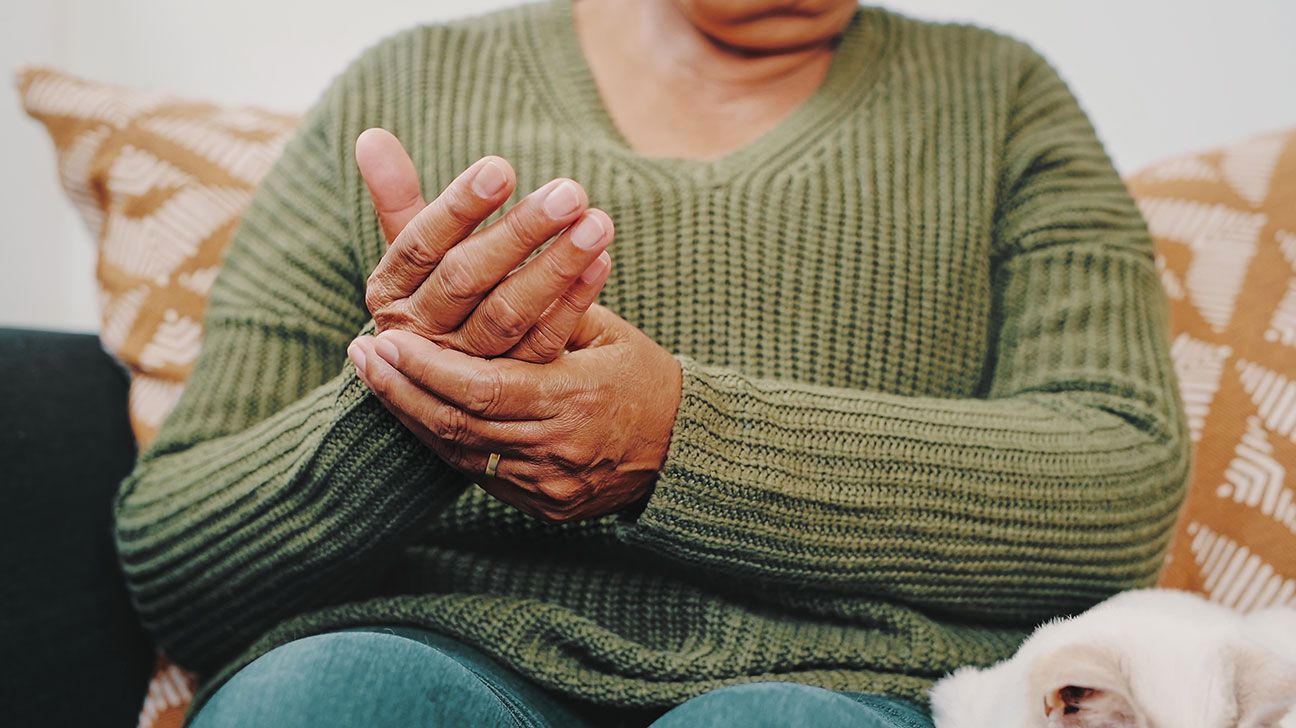 person with rheumatoid arthritis rubbing their painful hands-1