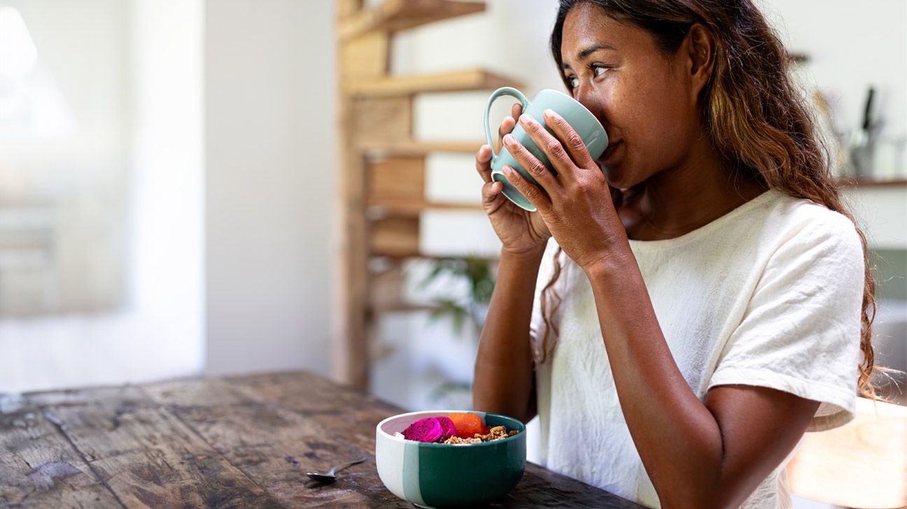 A woman drinking a cup of coffee.