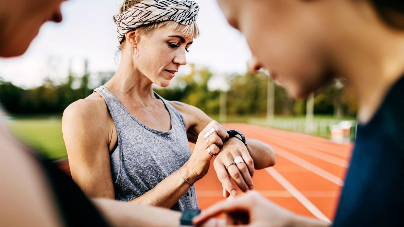 Woman checks smart watch while on a track.