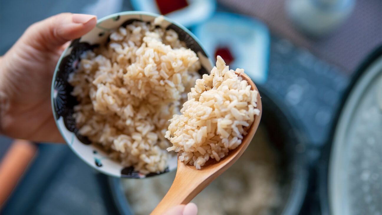 A bowl and spoon with brown rice.