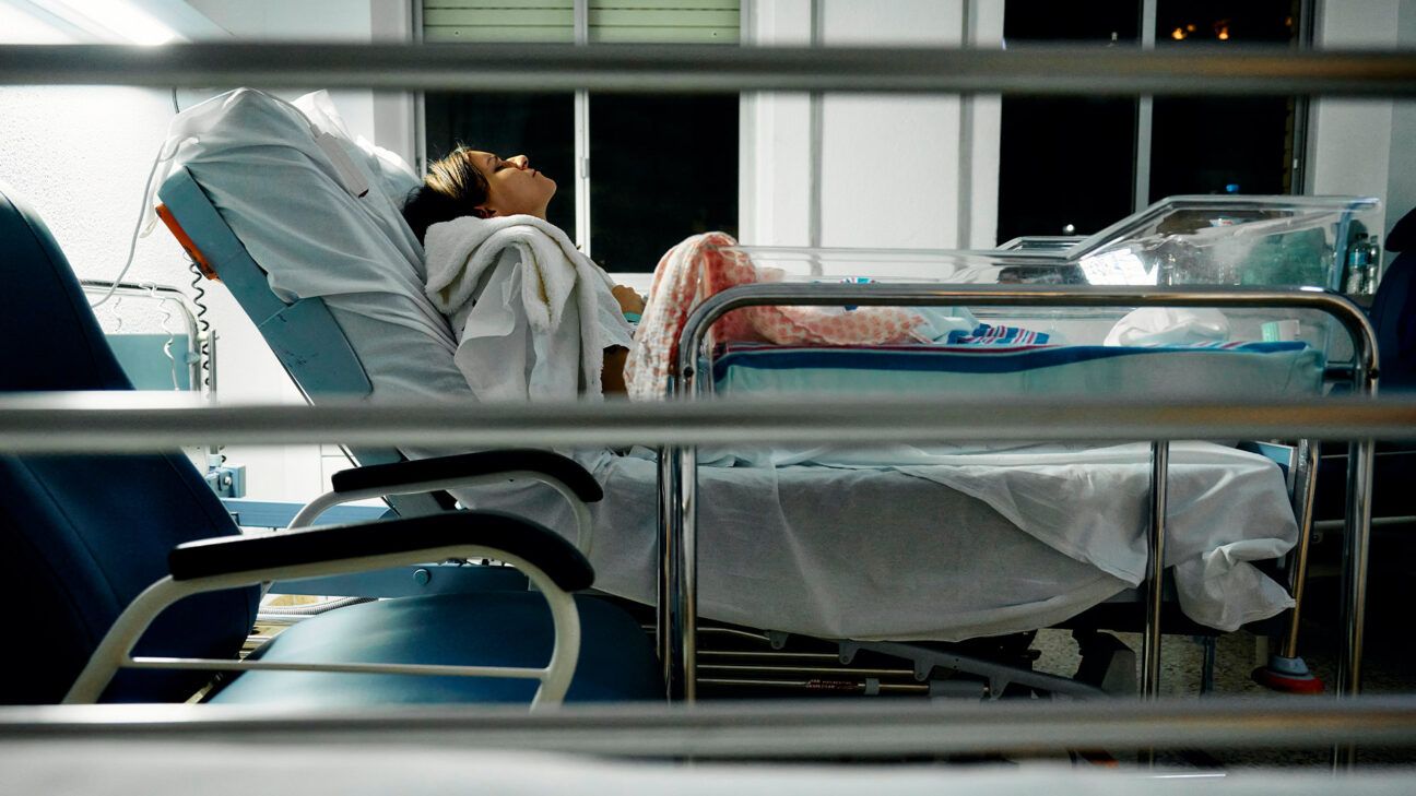 Woman in hospital bed seen from the side.