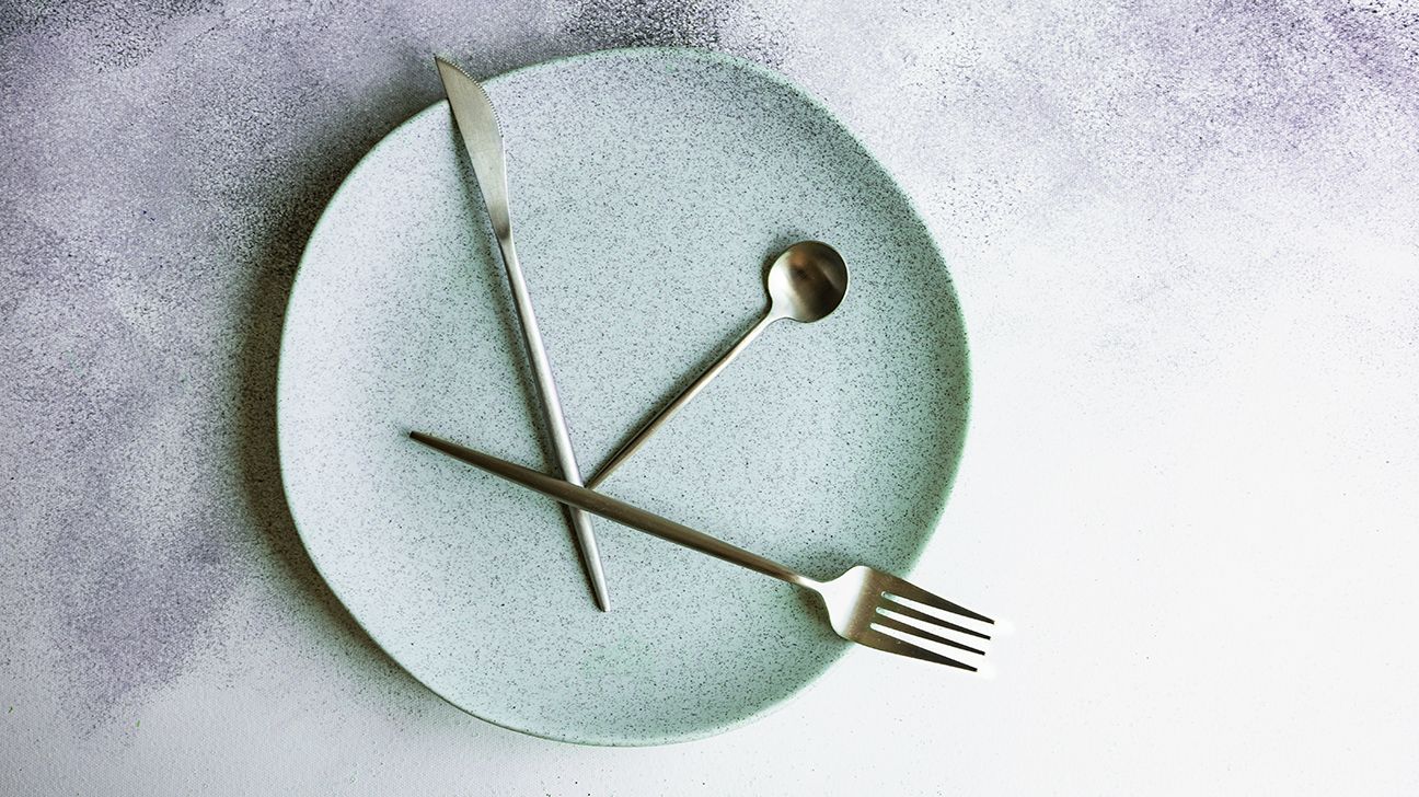A knife, spoon, and fork on a plate in the form of a clock