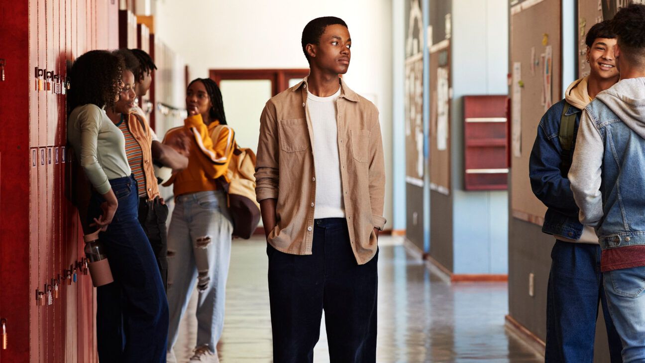 Teenagers standing in a school hallway.