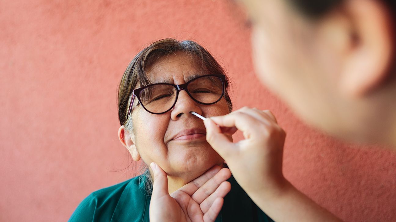 Person having a swab placed inside their nose to depict a COVID test.