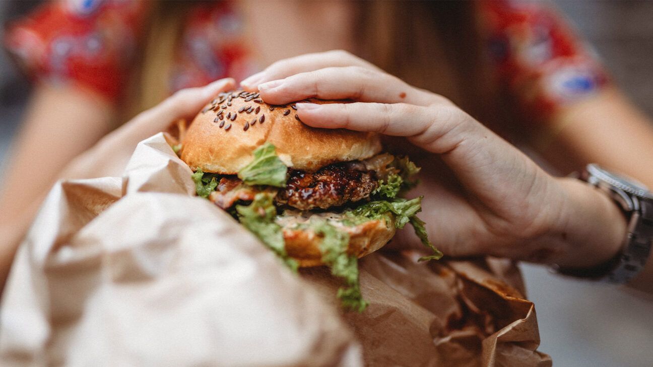 Woman holding a burger.