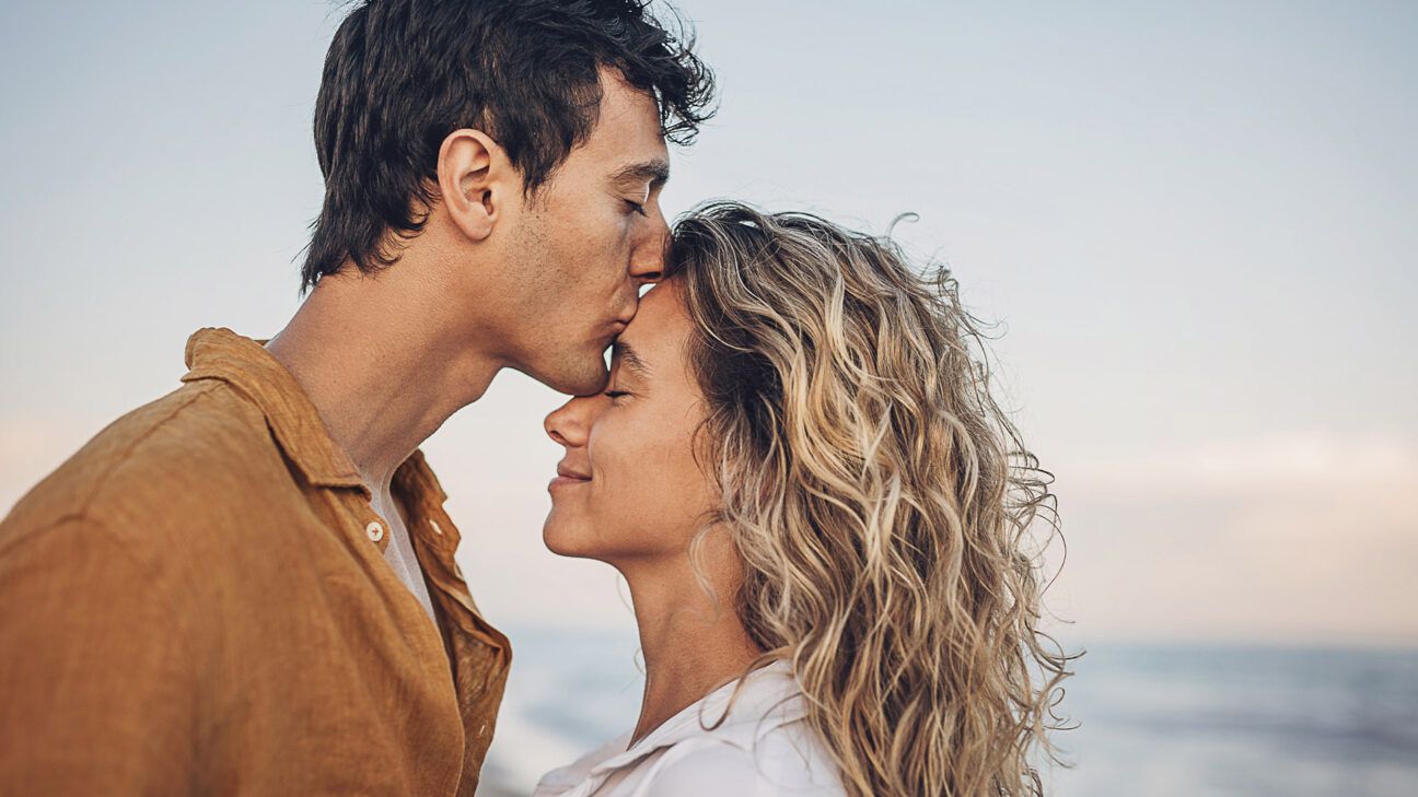 Male and female couple kissing at the beach