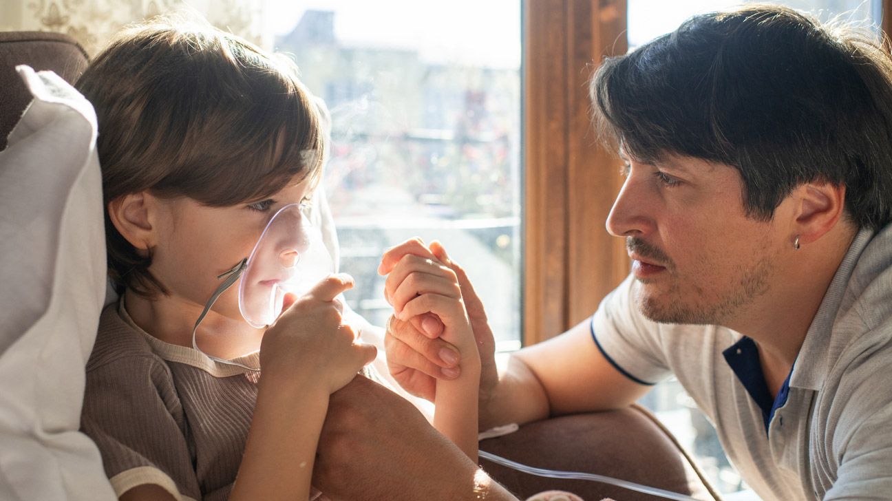 parent giving their child with cystic fibrosis a breathing treatment-1