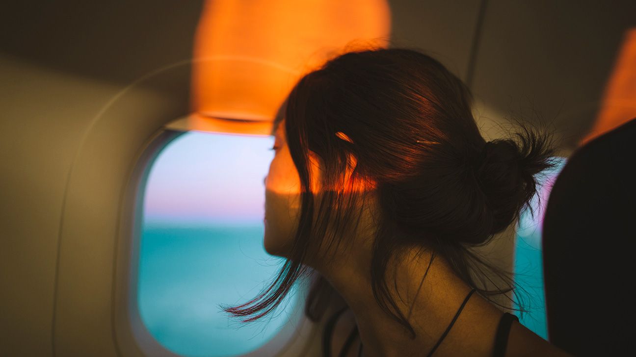 Female on plane looking out window