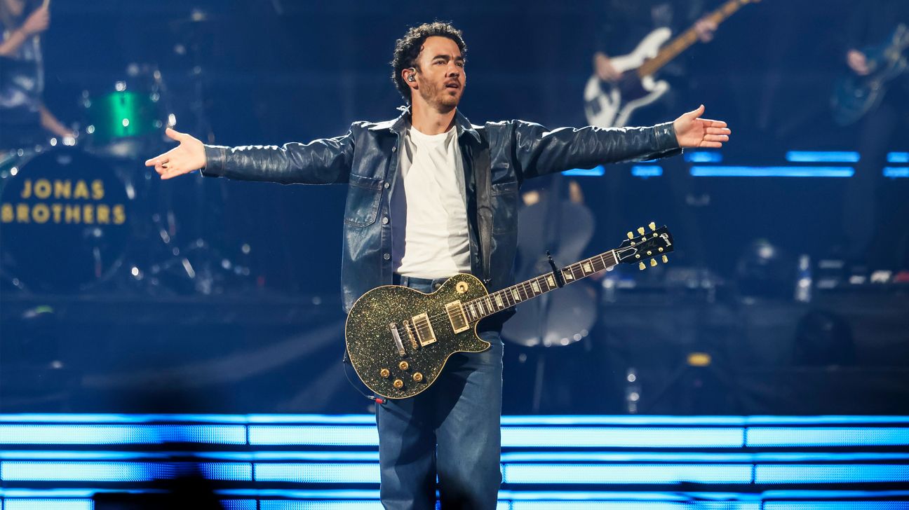 Musician Kevin Jonas is seen here on stage with a guitar.