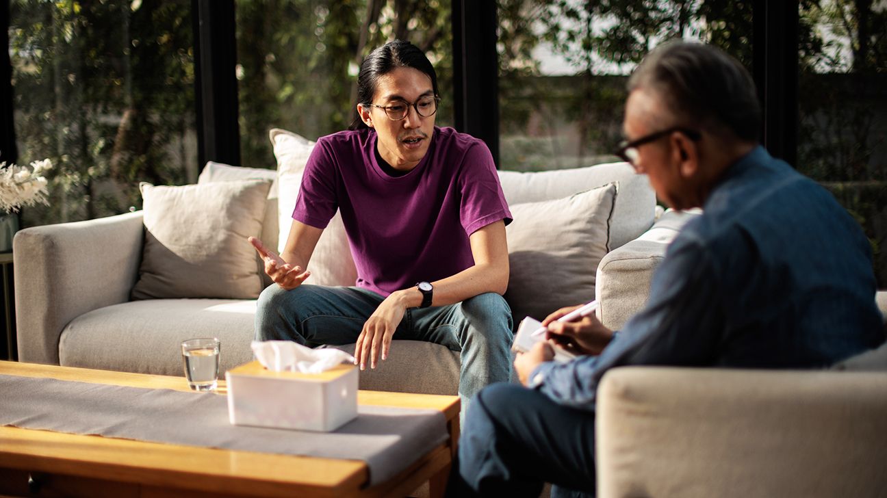 A young man chatting with a cognitive processing therapist during a regular session.