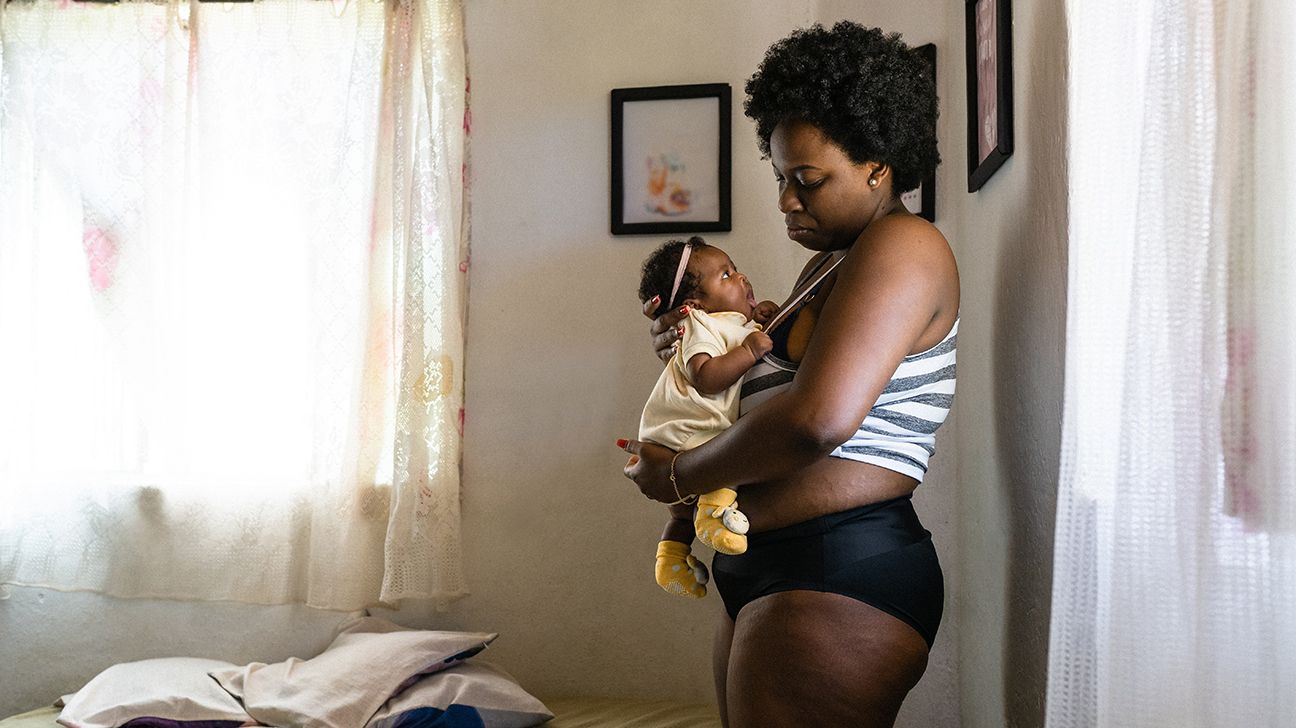 woman with postpartum thyroiditis holding her newborn-1