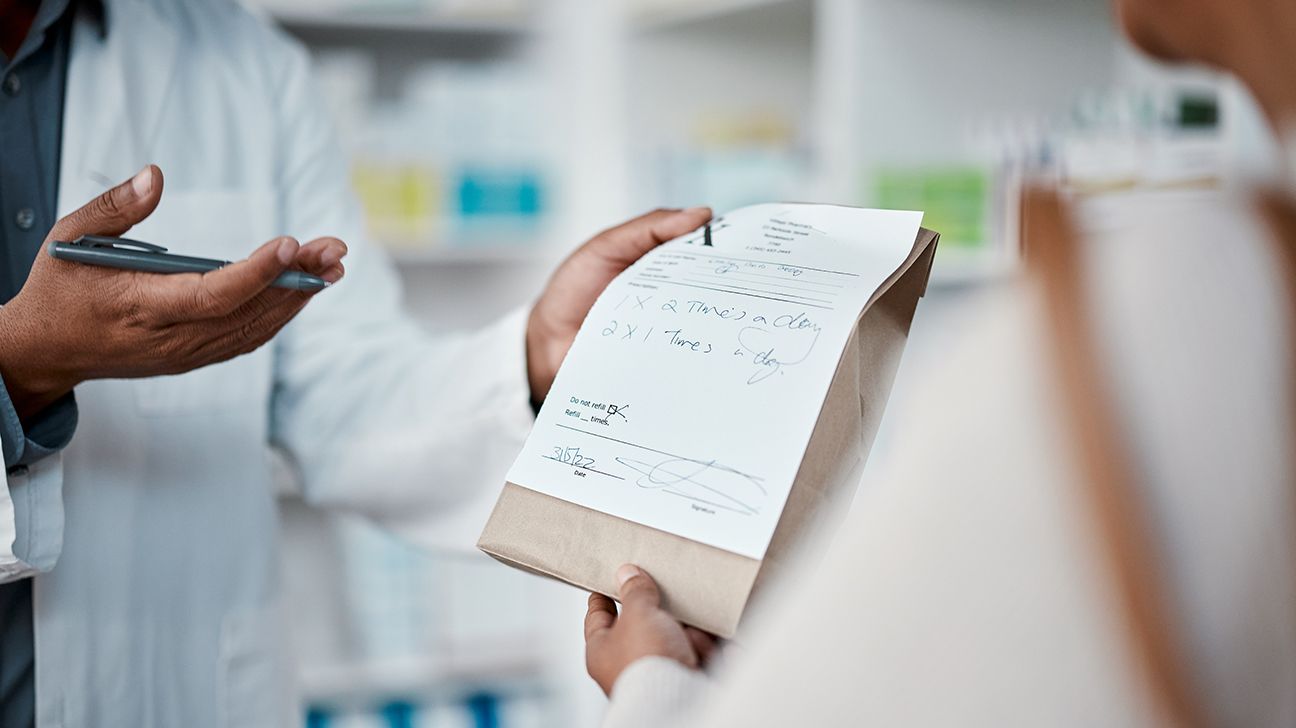 Pharmacist handing medication to a customer