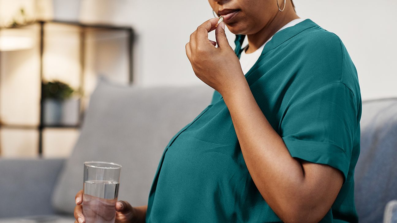 Mujer embarazada tomando vitaminas prenatales