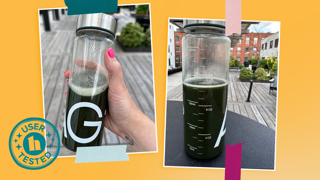 A clear AG1 bottle filled halfway with the greens supplement powder