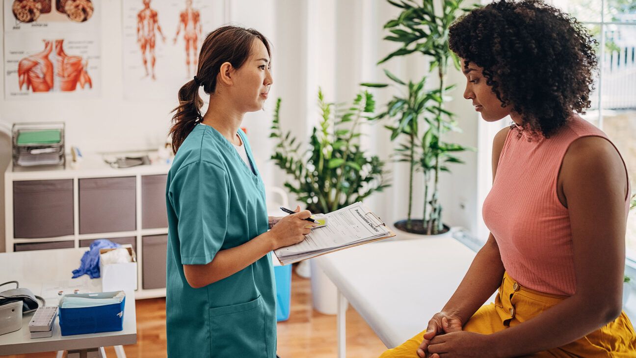 Female nurse talking with a female patient.