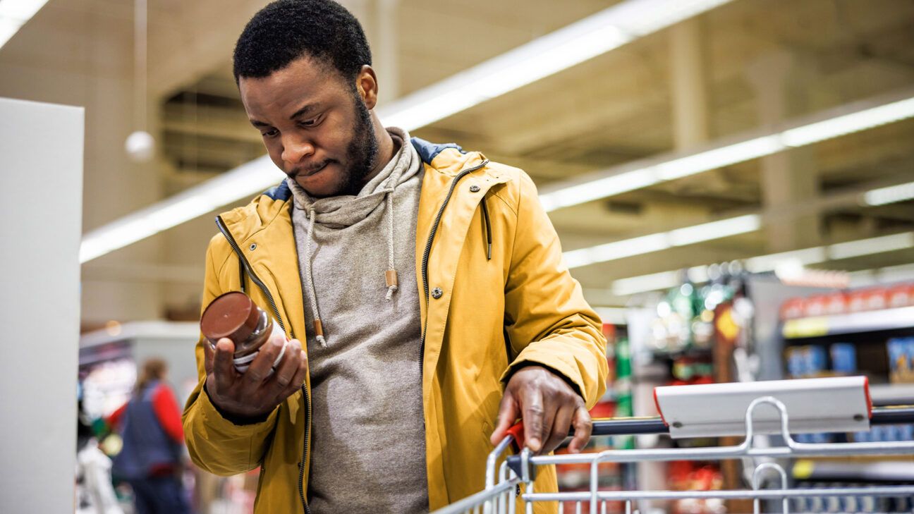 An adult male reading a food label.