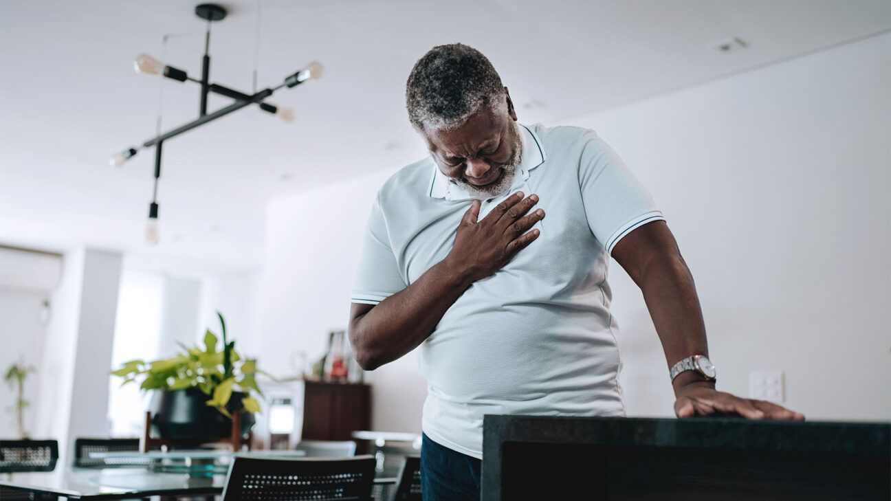 An older male experiencing heartburn.