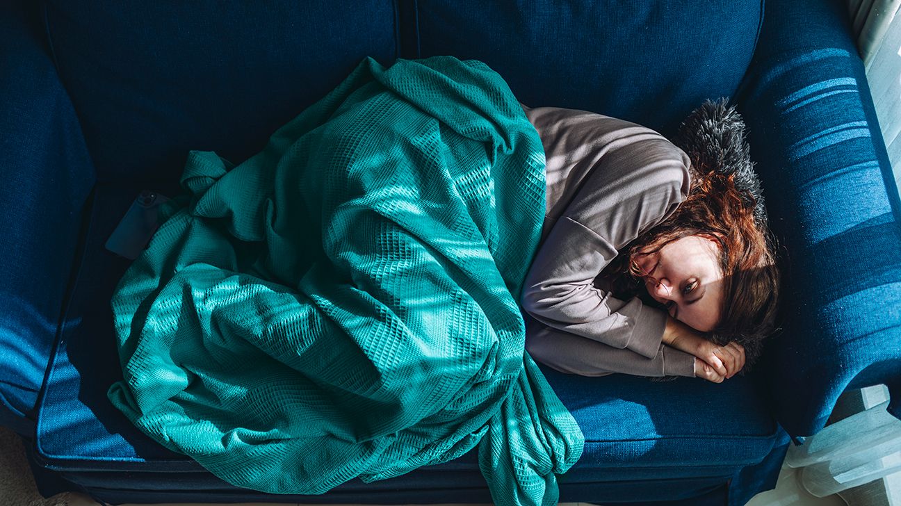 Woman with symptoms of depression lying down on a couch