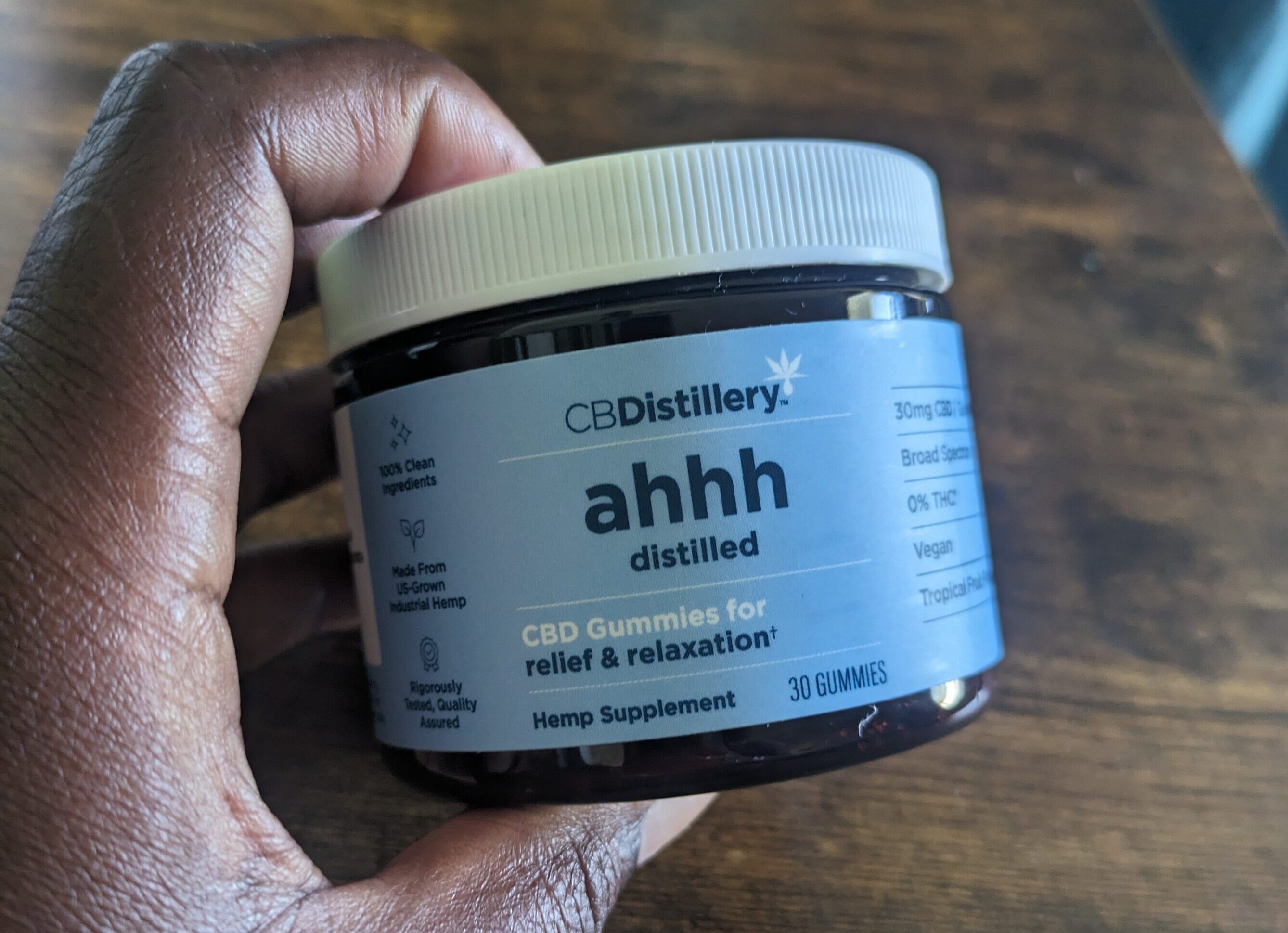 Healthline editor holding CBDistillery gummies container