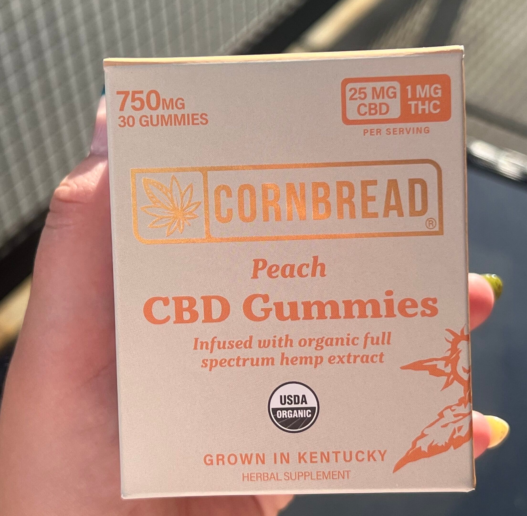 Healthline team member holding box of Cornbread Hemp gummies