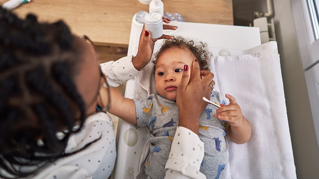 person applying ointment to baby's skin