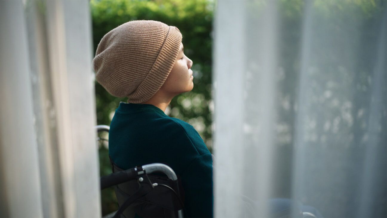 Young female adult with cancer sitting outside