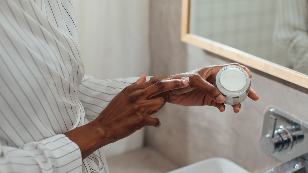 close up black woman testing cream on hand