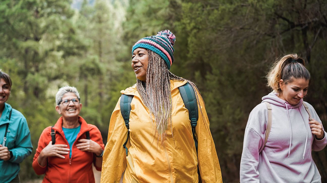 A group of women go hiking in the woods together