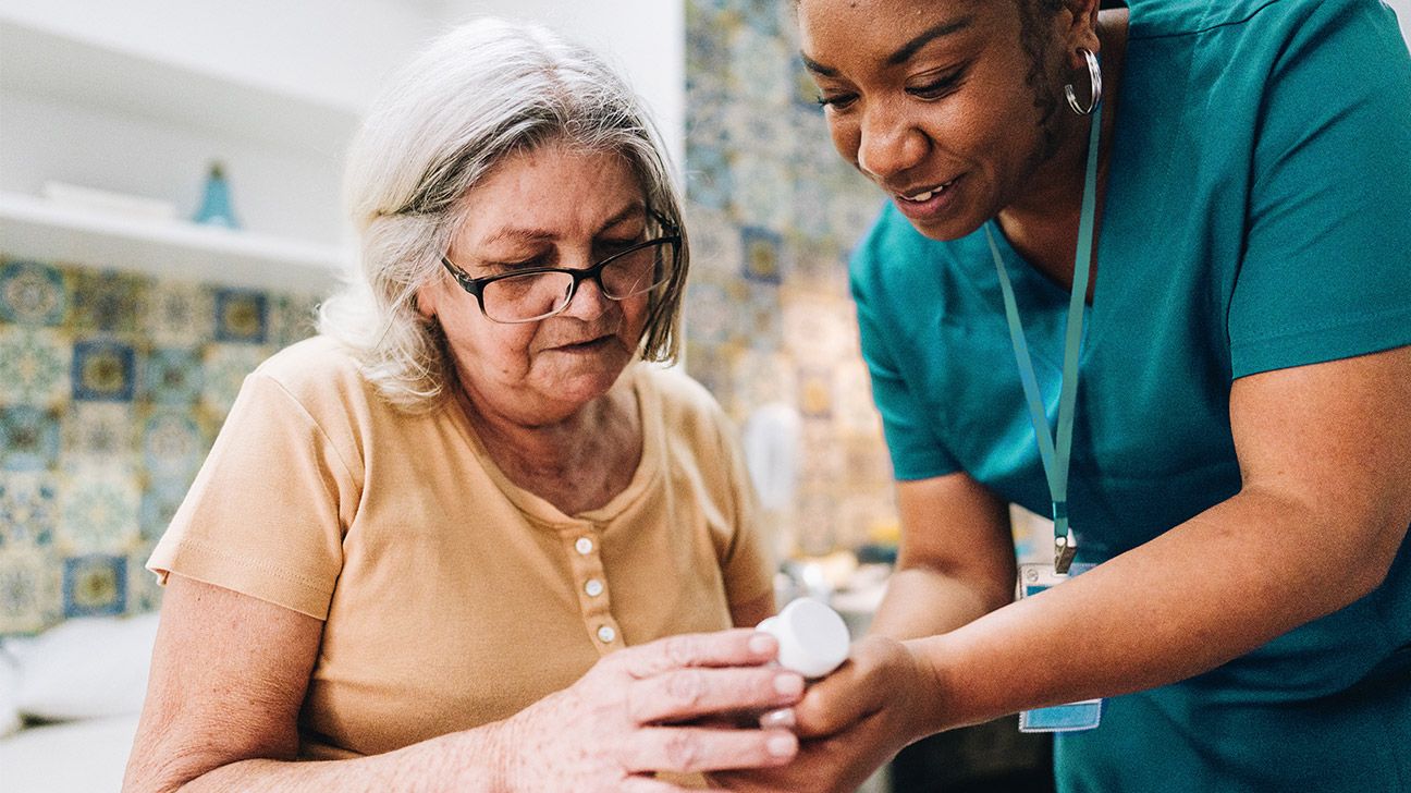 Nurse helping older patient with medication