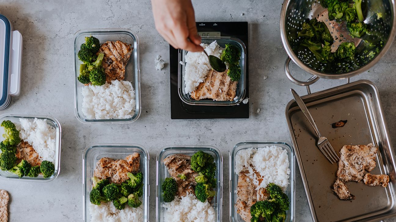 An overhead view of multiple meal prep containers, with chicken, broccoli, and rice in each