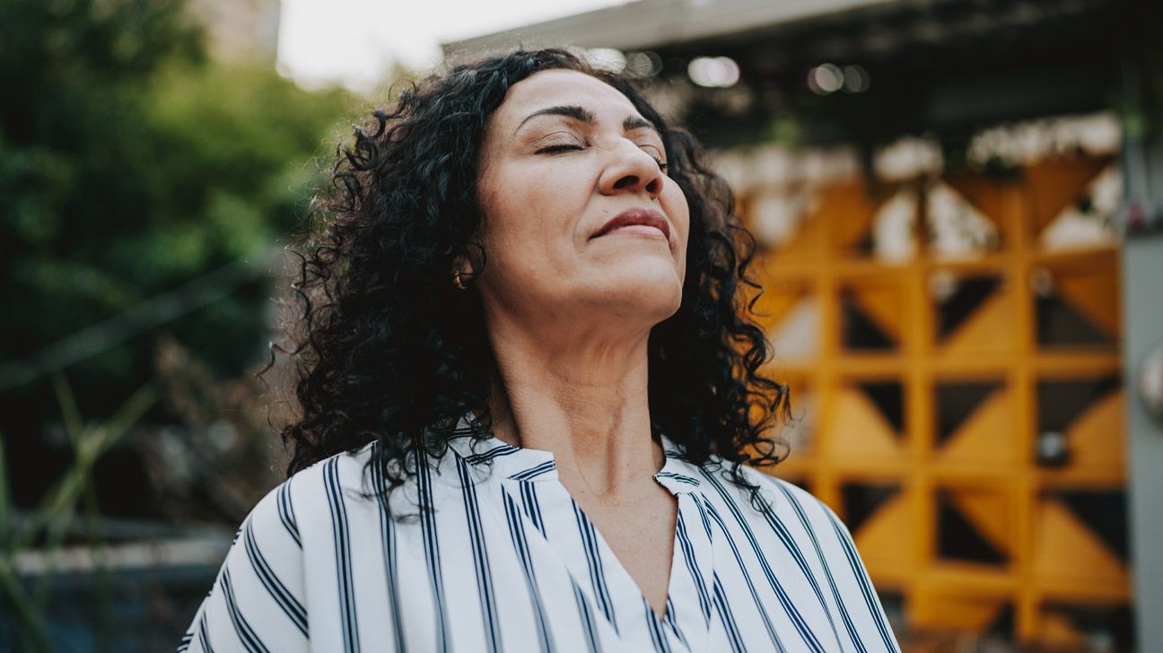 A woman meditates outside