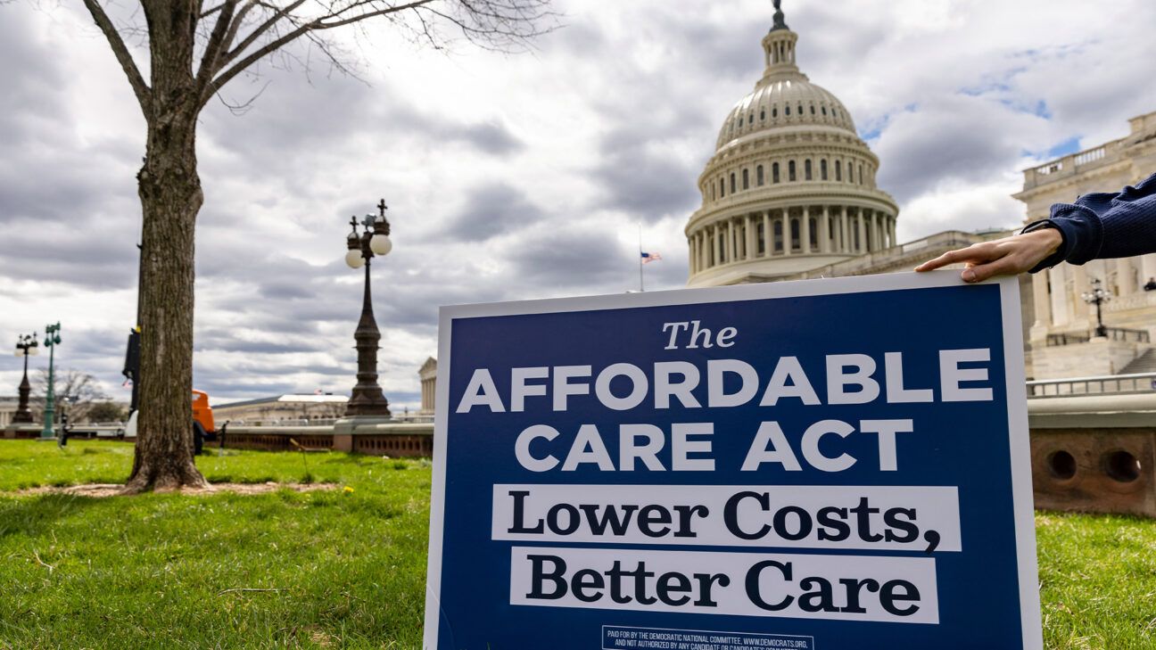 A person holding a sign outside the U.S. Capitol promoting the Affordable Care Act.