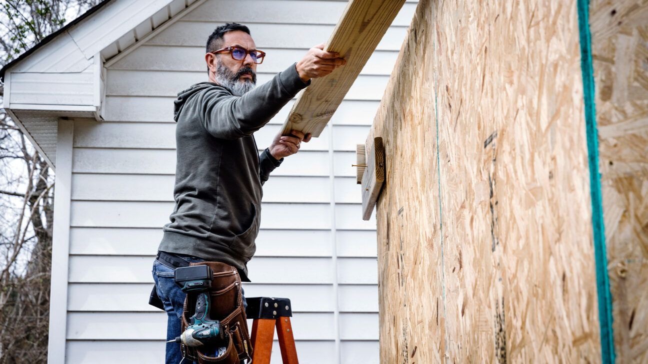 Adult male working on exterior of house