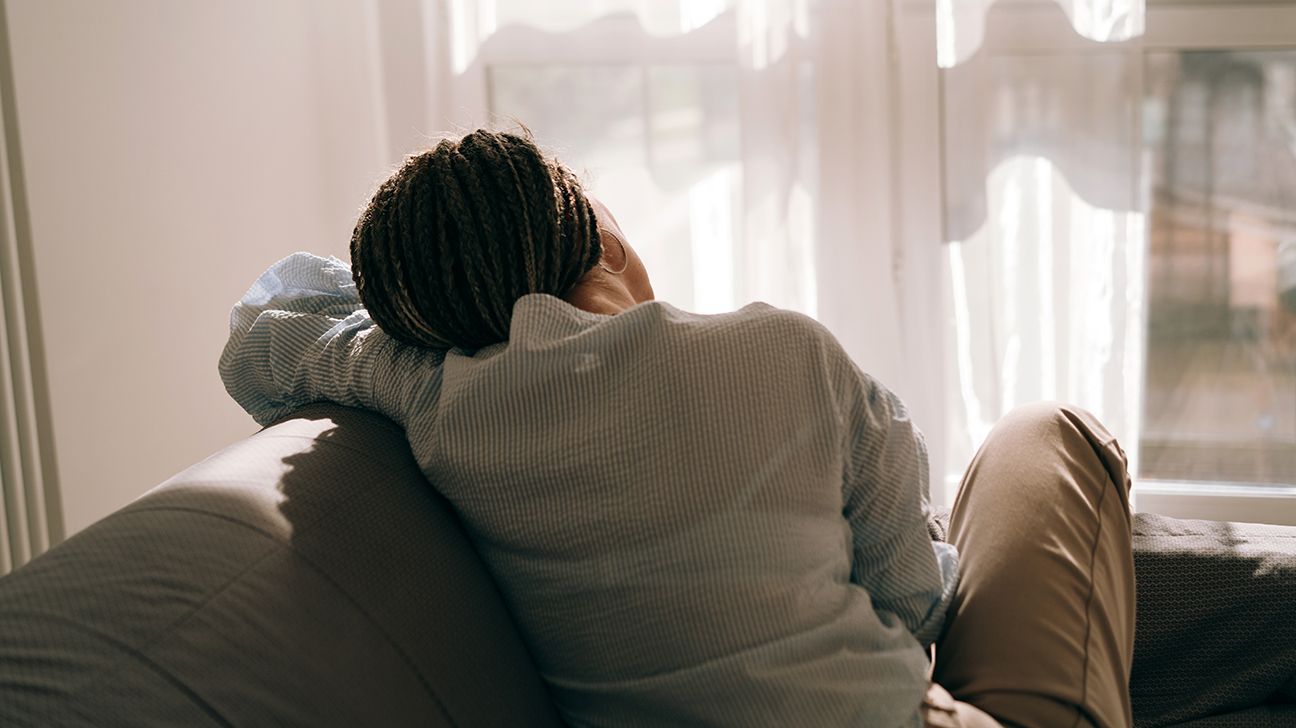 rear view back of woman sitting on sofa couch