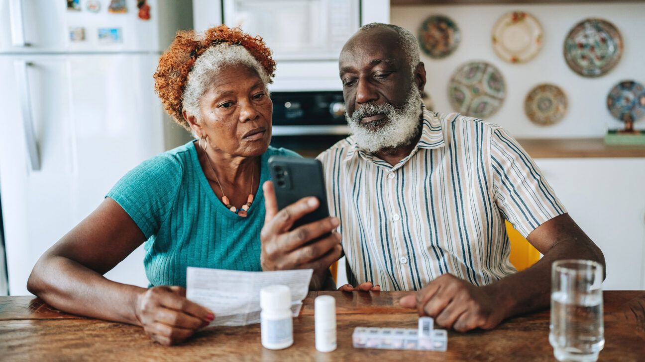 Older couple looking at prescription drugs, smartphone