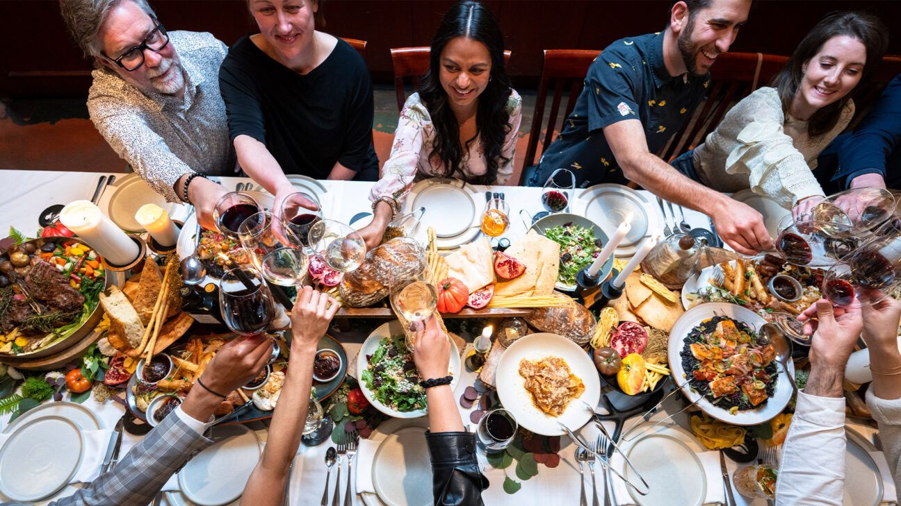 People sitting around a table enjoying a holiday meal together.