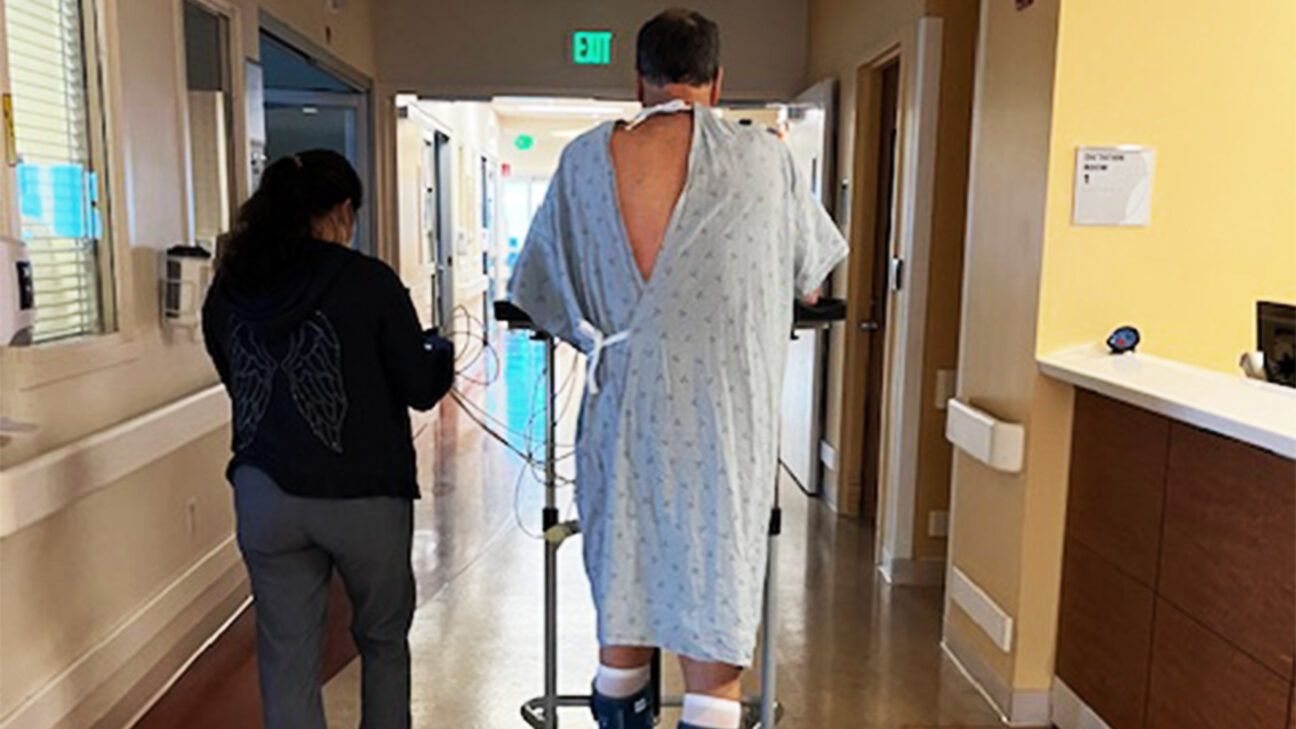 David Mills walking down a hospital a hospital hallway.