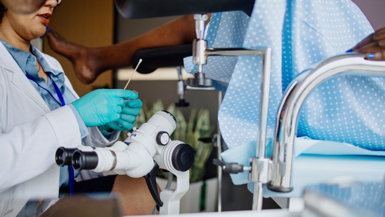 Female doctor administers pap test on patient