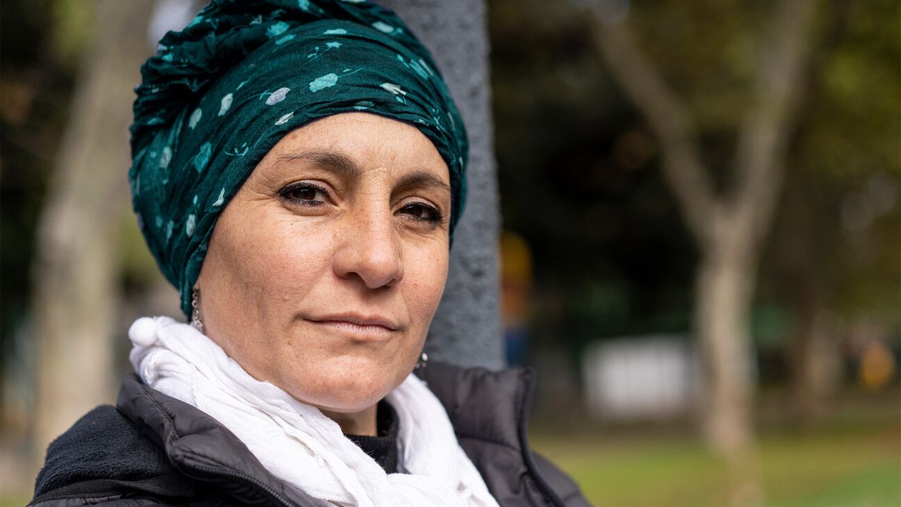 Female with cancer wearing headscarf sitting outdoors