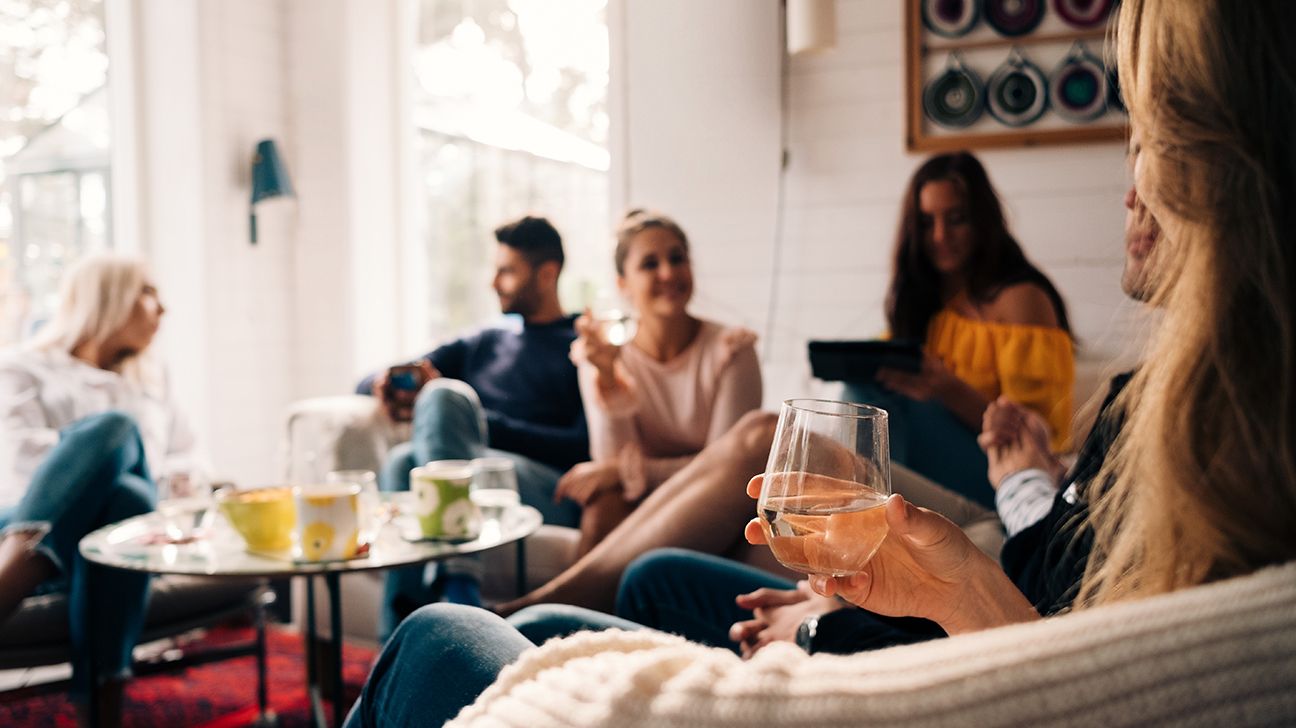 Friends in living room holding glasses