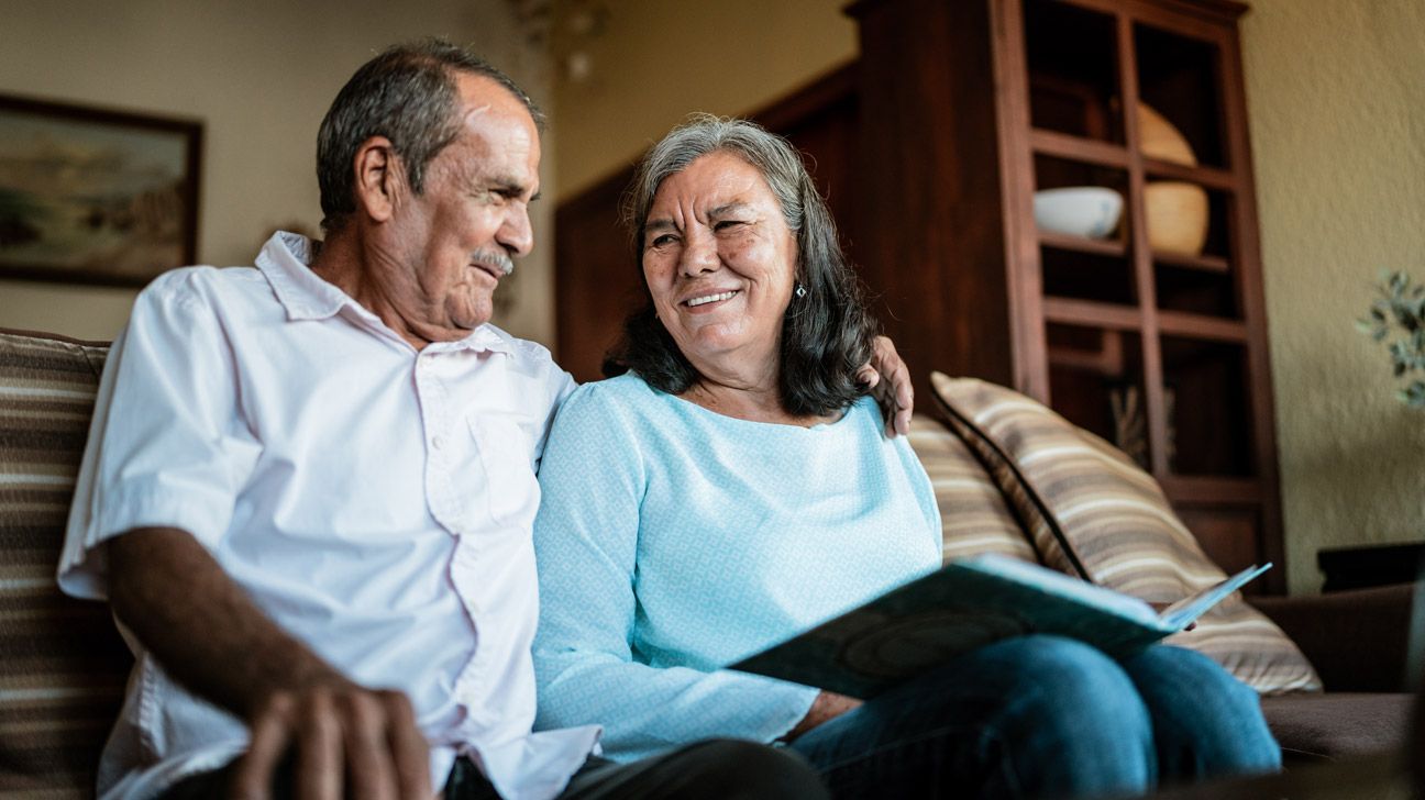 Older couple snuggling on a couch